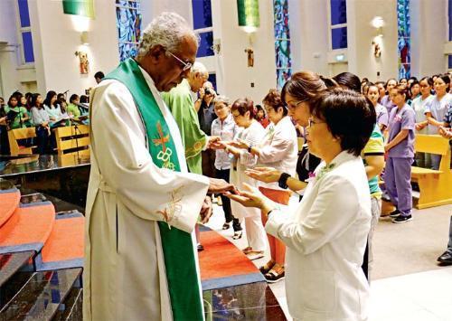 Mãos de enfermeiras são abençoadas durante cerimônia especial em Singapura.jpg