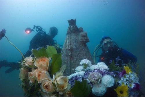 Mergulhadores levam oferenda floral para imagem de Nossa Senhora na Espanha.jpg